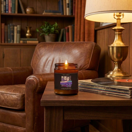 The Lou 4oz candle lit on a walnut side table in a vintage den