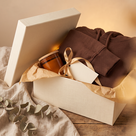 The Lampley Mystery Comfort Box, a cream gift box with camel tissue, a surprise hoodie and hand-poured soy candle inside