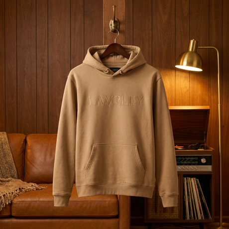 Camel LAMPLEY hoodie hanging in a vintage wood-paneled den