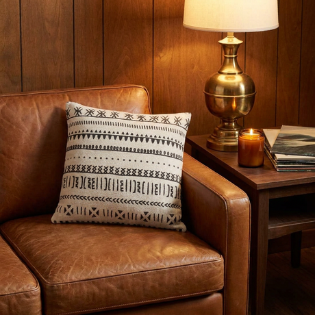 Natural mud cloth pillow on a leather sofa in a vintage den