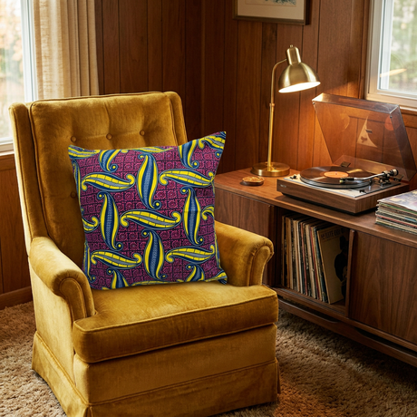 Purple and yellow African print pillow cover on a vintage mustard velvet armchair beside a record player
