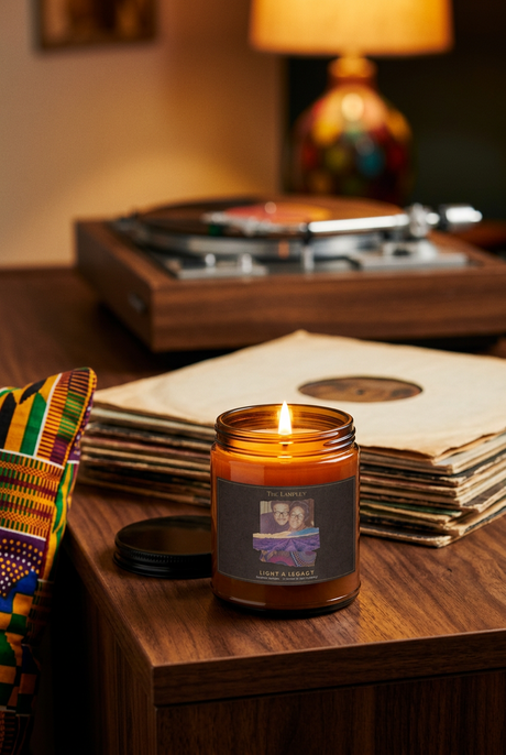 The Lou soy candle lit beside a stack of vintage vinyl records and a turntable